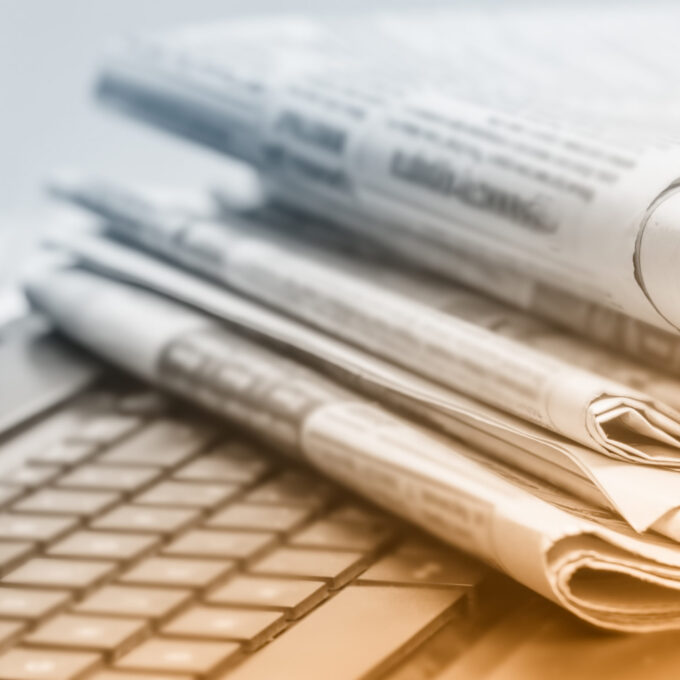 Gazety leżące na klawiaturze laptopa